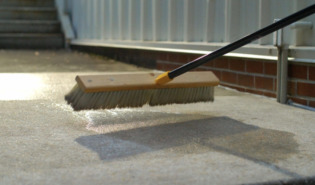 a broom sweeping the sidewalk